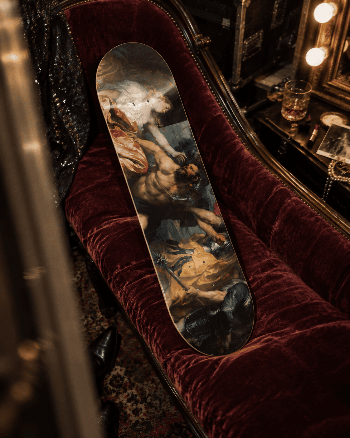 Rubens Samson and Delilah skateboard wall art resting on a red velvet chaise in a theater dressing room