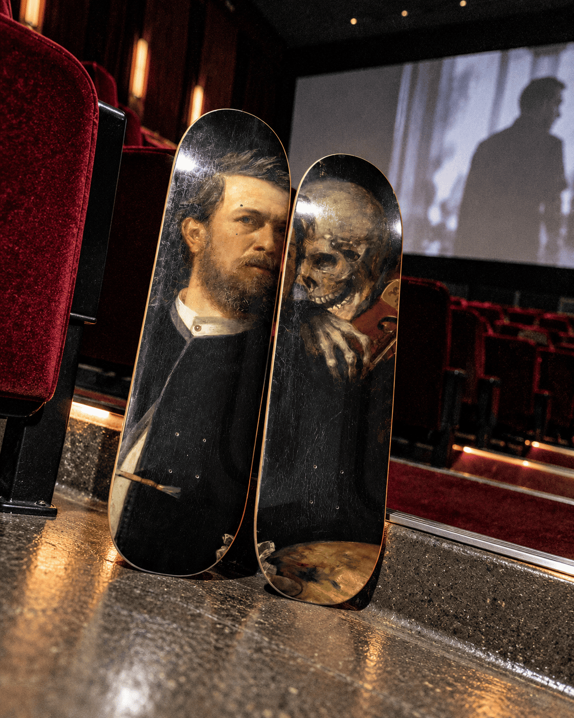 Böcklin self-portrait with death skateboard wall art standing on a cinema floor before red velvet seats, with a silhouette on the screen