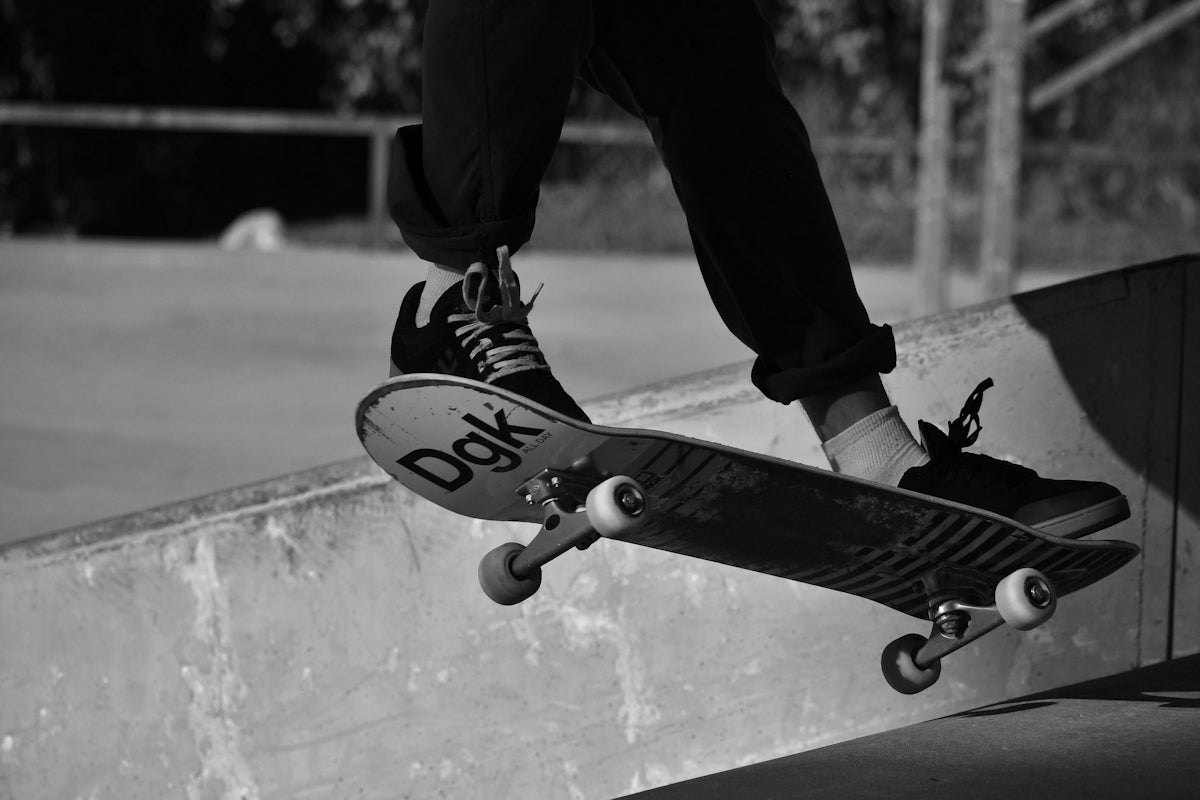 grayscale photography of person skating on mid air