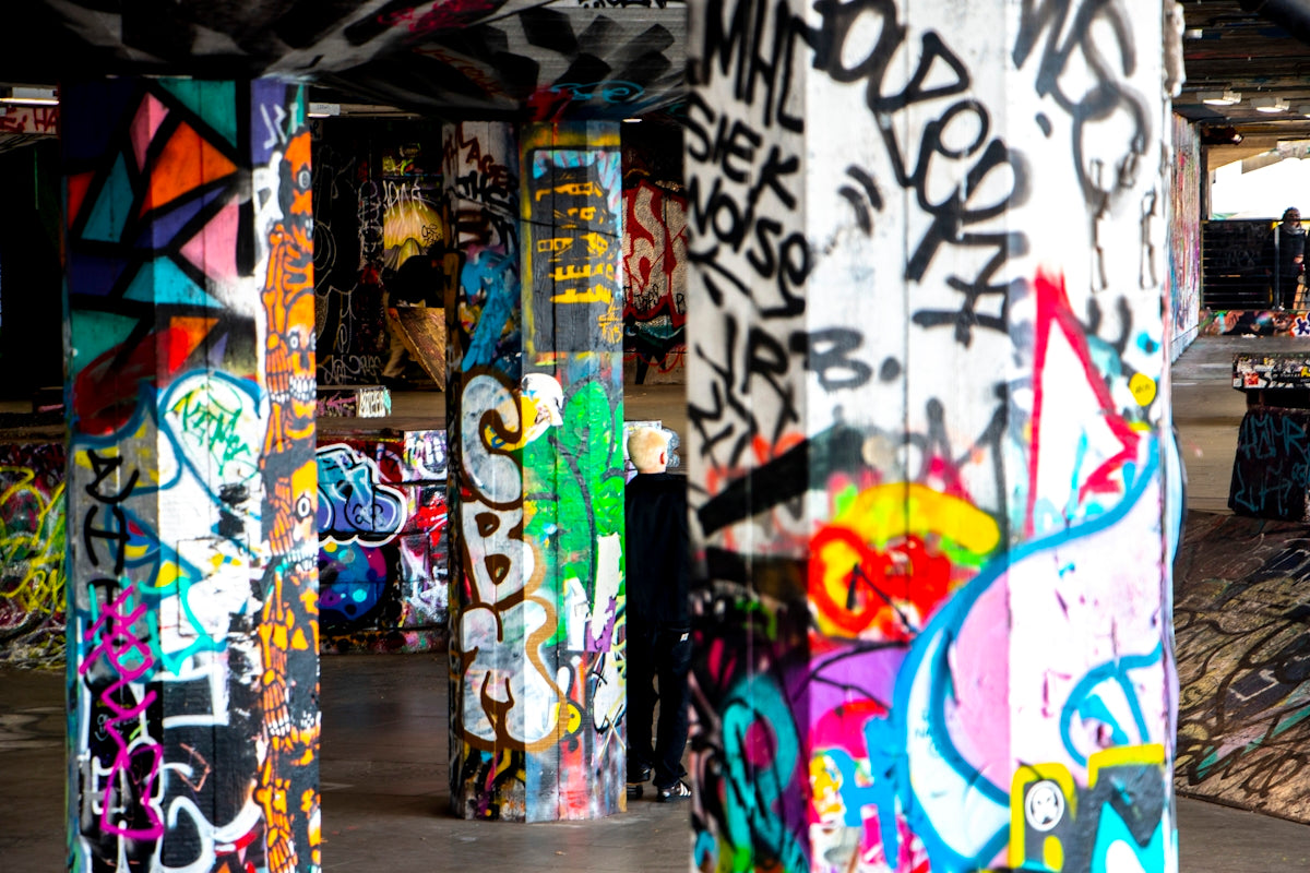 a group of graffiti covered pillars in a parking garage